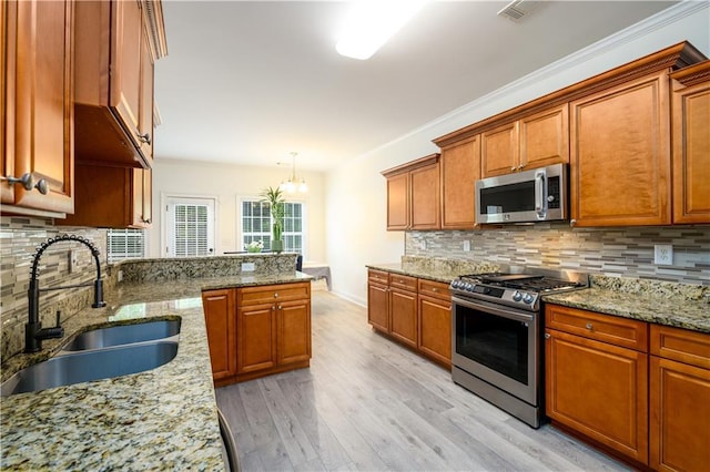 1076 Scenic Park Trl, Lawrenceville, GA 30046 - kitchen featuring appliances with stainless steel finishes, a sink, light wood-type flooring, decorative backsplash, and brown cabinetry