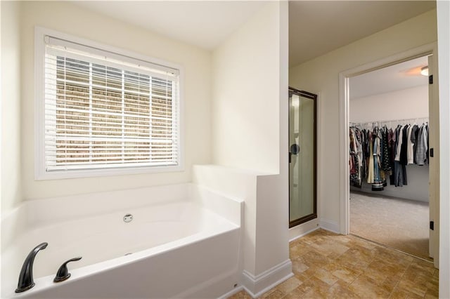 1076 Scenic Park Trl, Lawrenceville, GA 30046 - full bath featuring a garden tub, a shower stall, a spacious closet, baseboards, and stone finish floors