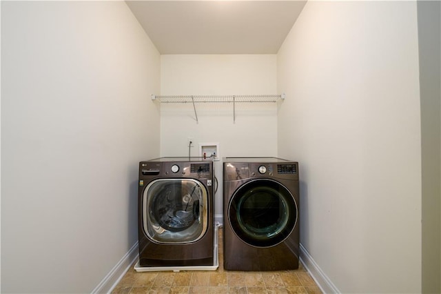 1076 Scenic Park Trl, Lawrenceville, GA 30046 - washroom with washer and clothes dryer, baseboards, and stone finish floors