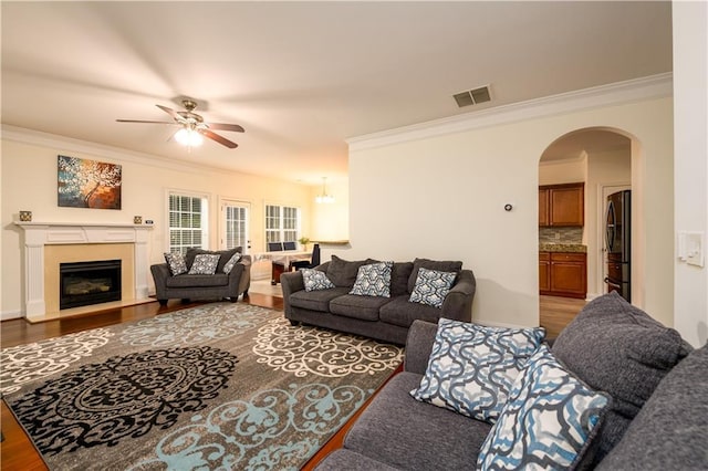 1076 Scenic Park Trl, Lawrenceville, GA 30046 - living room with ornamental molding, a ceiling fan, arched walkways, wood finished floors, and a fireplace