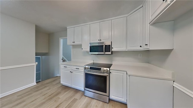 1102 Tony Valley Dr, Conyers, GA 30013 - kitchen with appliances with stainless steel finishes, light wood finished floors, white cabinets, and light countertops