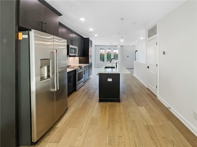 371 Pratt Dr SE Unit 203, Atlanta, GA 30315 - kitchen featuring stainless steel appliances, hanging light fixtures, a sink, a center island with sink, and light countertops