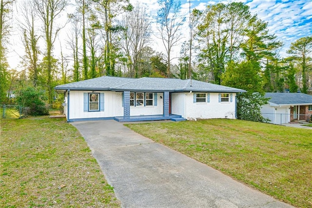 ranch-style house featuring board and batten siding, a front lawn, and fence