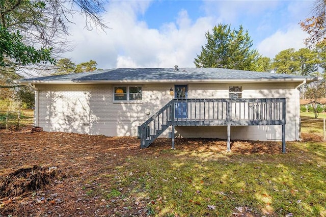 back of property featuring a lawn and a deck