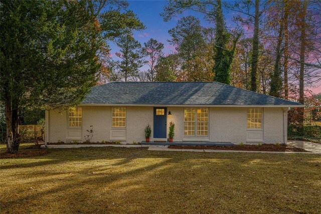 single story home featuring a lawn