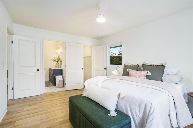 bedroom with a closet, ceiling fan, hardwood / wood-style floors, and a walk in closet