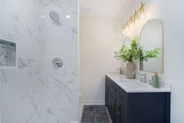 bathroom with vanity and a tile shower