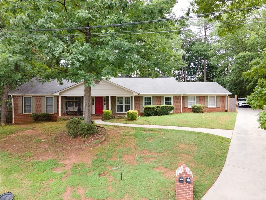 ranch-style house with brick siding and a front yard