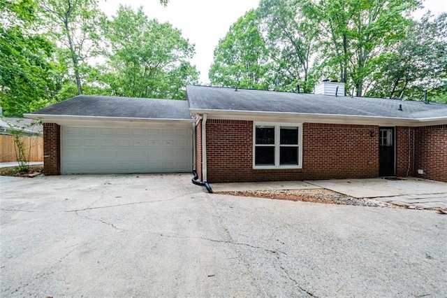 single story home with brick siding, a chimney, fence, a garage, and driveway