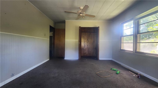 unfurnished bedroom featuring dark colored carpet and ceiling fan