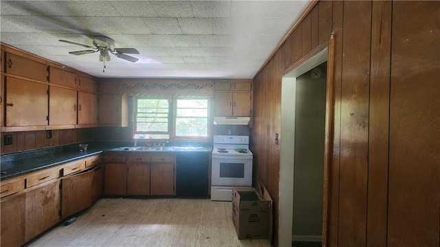 kitchen with ceiling fan, light wood-type flooring, wood walls, sink, and white range oven