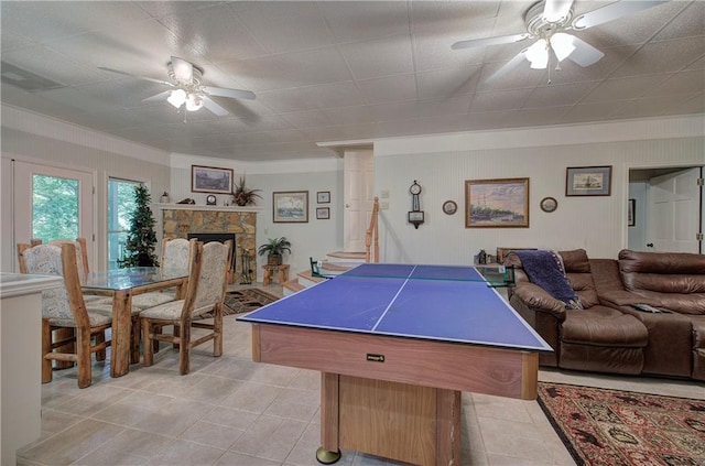 recreation room featuring ceiling fan, light tile patterned flooring, and a fireplace