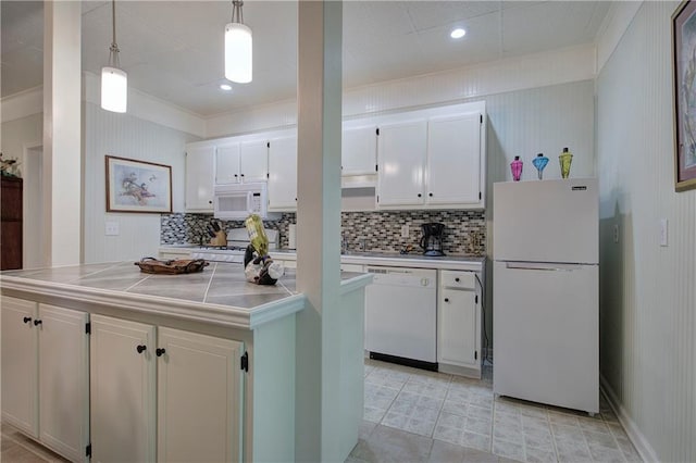 kitchen featuring white cabinets, decorative backsplash, white appliances, and hanging light fixtures