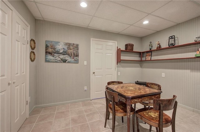 tiled dining area featuring a drop ceiling