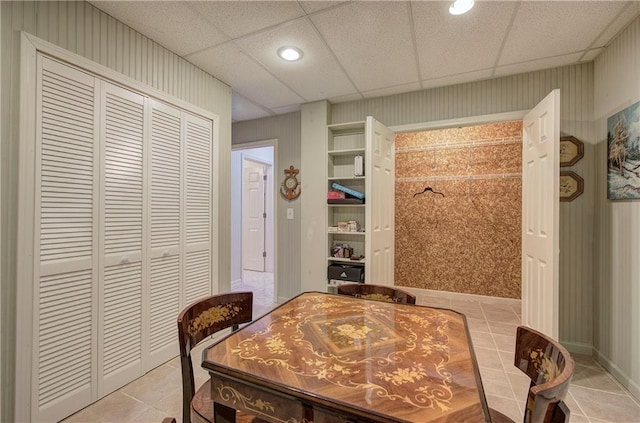 dining room featuring a paneled ceiling and light tile patterned floors