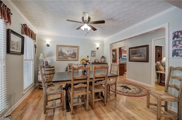 dining space featuring a textured ceiling, crown molding, and light hardwood / wood-style flooring
