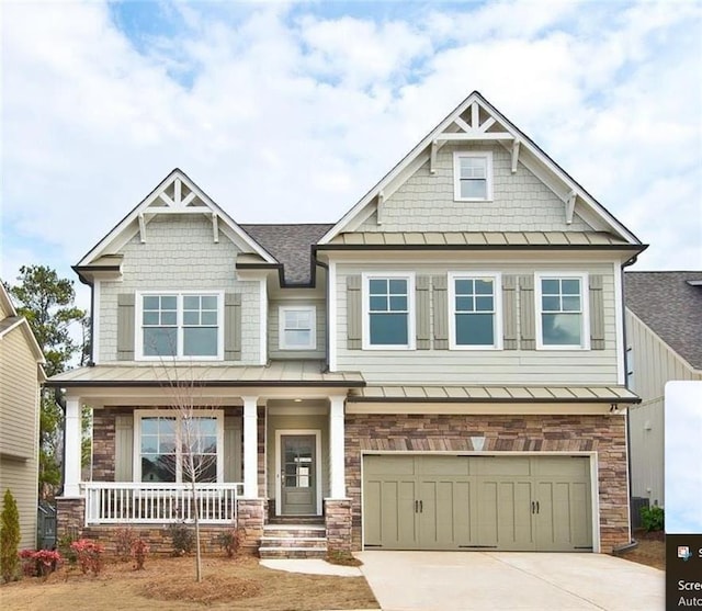 craftsman house featuring a standing seam roof, stone siding, a porch, concrete driveway, and a garage