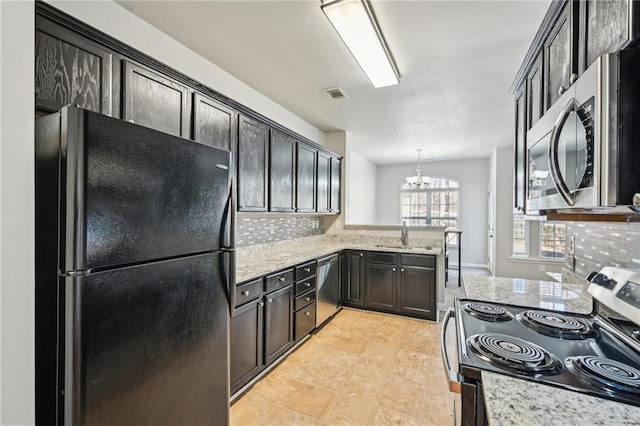 2726 Pierce Brennen Ct, Lawrenceville, GA 30043 - kitchen featuring visible vents, a notable chandelier, tasteful backsplash, appliances with stainless steel finishes, and light stone countertops