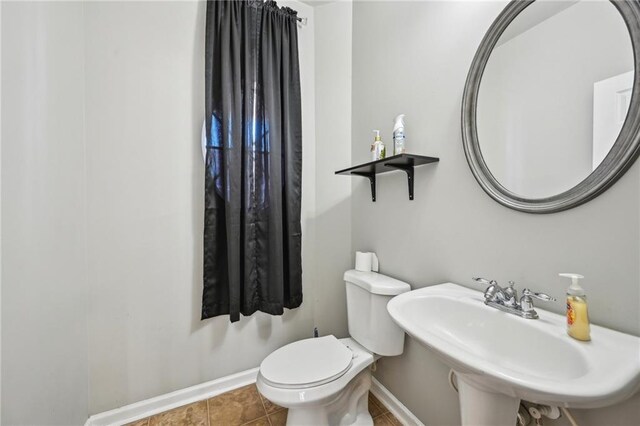 2726 Pierce Brennen Ct, Lawrenceville, GA 30043 - half bath featuring tile patterned flooring, toilet, baseboards, and a sink