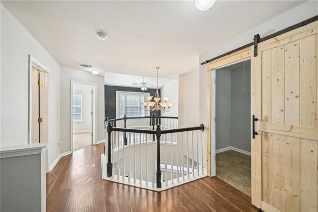 2726 Pierce Brennen Ct, Lawrenceville, GA 30043 - hallway featuring a barn door, wood finished floors, visible vents, and a chandelier