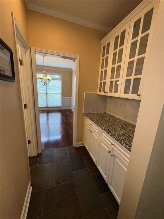 3381 Walkers Ridge Rd, Dacula, GA 30019 - kitchen featuring glass insert cabinets, a chandelier, white cabinets, crown molding, and dark stone countertops