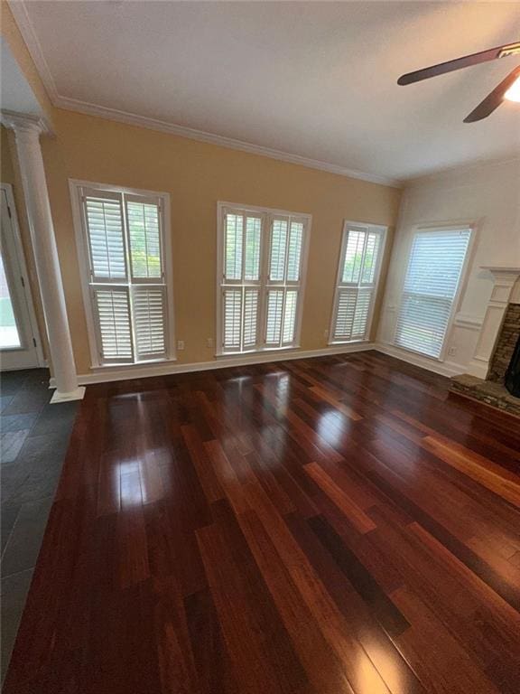 3381 Walkers Ridge Rd, Dacula, GA 30019 - unfurnished living room featuring a ceiling fan, a fireplace with raised hearth, decorative columns, dark wood-style flooring, and healthy amount of natural light