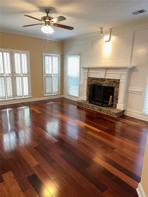3381 Walkers Ridge Rd, Dacula, GA 30019 - unfurnished living room with a ceiling fan, dark wood-style flooring, a stone fireplace, crown molding, and baseboards