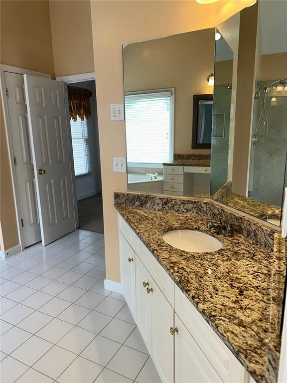 3381 Walkers Ridge Rd, Dacula, GA 30019 - bathroom with tile patterned floors, baseboards, vanity, and a tile shower