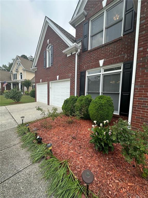 3381 Walkers Ridge Rd, Dacula, GA 30019 - view of property exterior with brick siding, a garage, and driveway