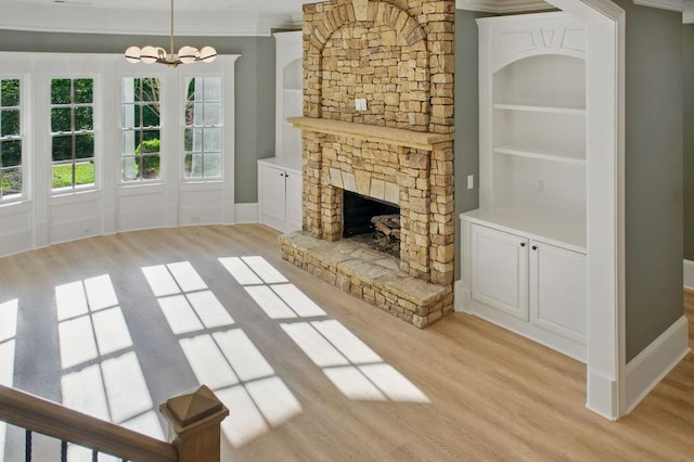 6756 Hedge Row Ln, Gainesville, GA 30506 - unfurnished living room featuring light wood-type flooring, a chandelier, a fireplace, ornamental molding, and built in shelves