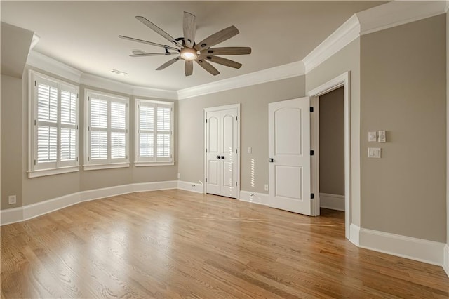 empty room with crown molding, a ceiling fan, and light wood-style floors
