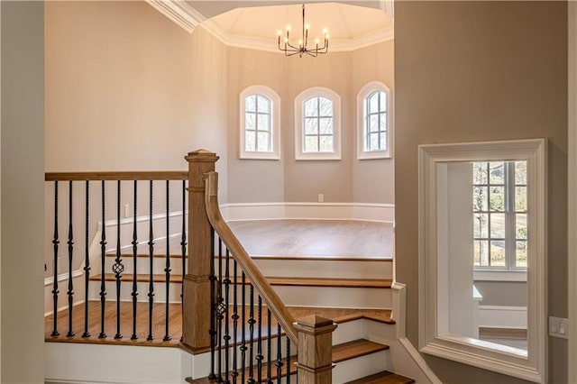 stairway with crown molding and a notable chandelier