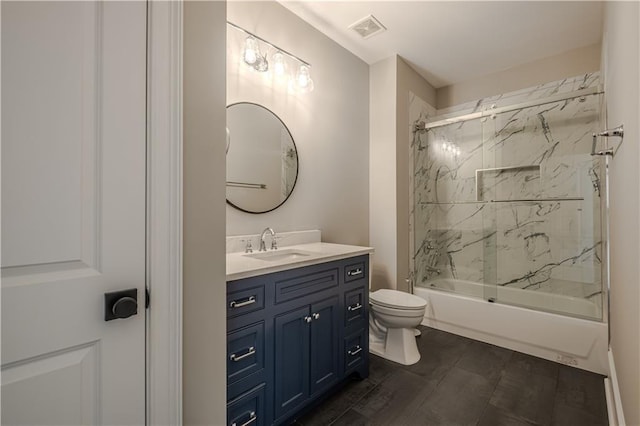 bathroom with vanity, combined bath / shower with glass door, toilet, and visible vents