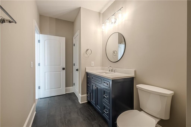 bathroom with toilet, baseboards, and vanity