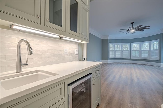 6756 Hedge Row Ln, Gainesville, GA 30506 - kitchen featuring wine cooler, a sink, crown molding, tasteful backsplash, and baseboards