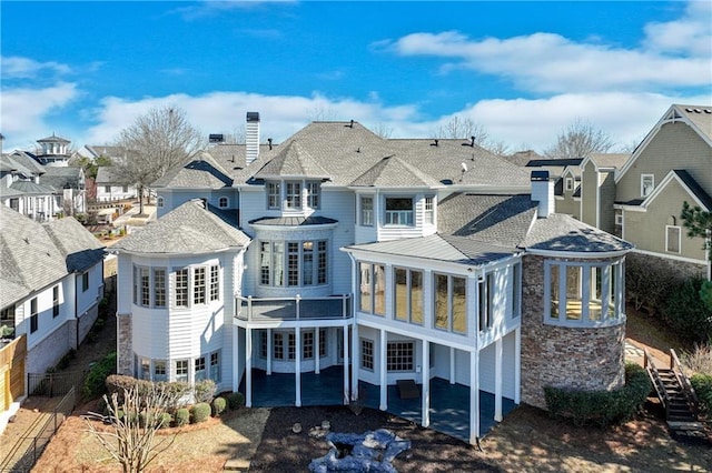 6756 Hedge Row Ln, Gainesville, GA 30506 - rear view of house featuring a sunroom, stone siding, a residential view, a chimney, and a standing seam roof