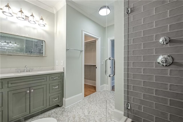 bathroom featuring vanity, ornamental molding, baseboards, and a shower stall