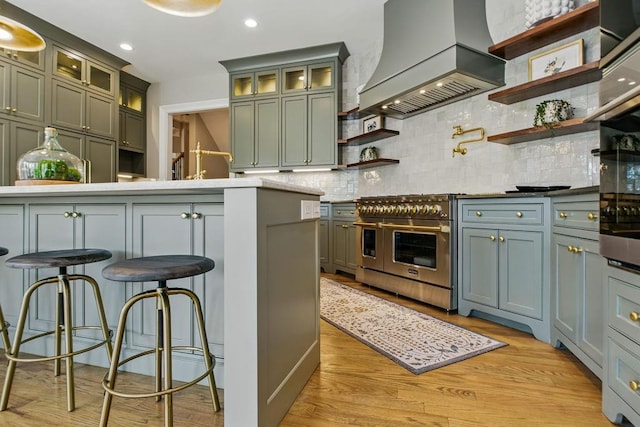 6756 Hedge Row Ln, Gainesville, GA 30506 - kitchen featuring custom range hood, double oven range, open shelves, decorative backsplash, and light wood-style floors