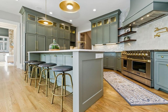 6756 Hedge Row Ln, Gainesville, GA 30506 - kitchen with premium range hood, double oven range, light wood-style flooring, decorative backsplash, and light countertops