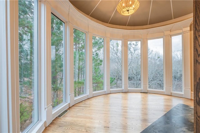 unfurnished sunroom with visible vents and wood finished floors