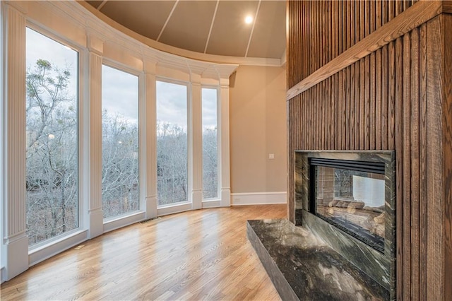 unfurnished living room with visible vents, a multi sided fireplace, and a healthy amount of sunlight