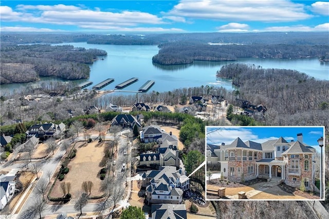 birds eye view of property featuring a water view and a wooded view