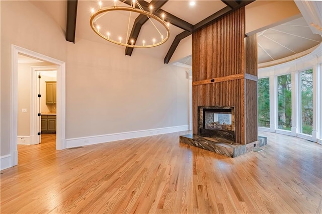 unfurnished living room featuring a multi sided fireplace, baseboards, an inviting chandelier, and light wood-type flooring