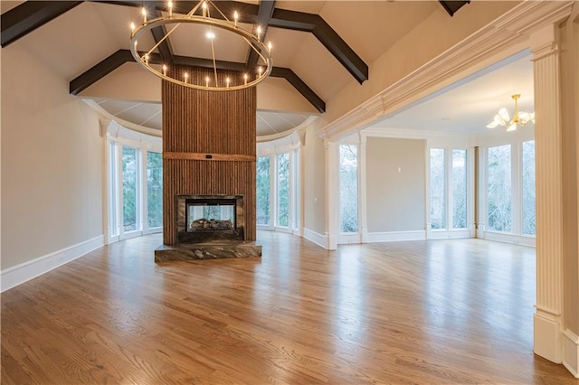unfurnished living room with baseboards, beamed ceiling, an inviting chandelier, and wood finished floors