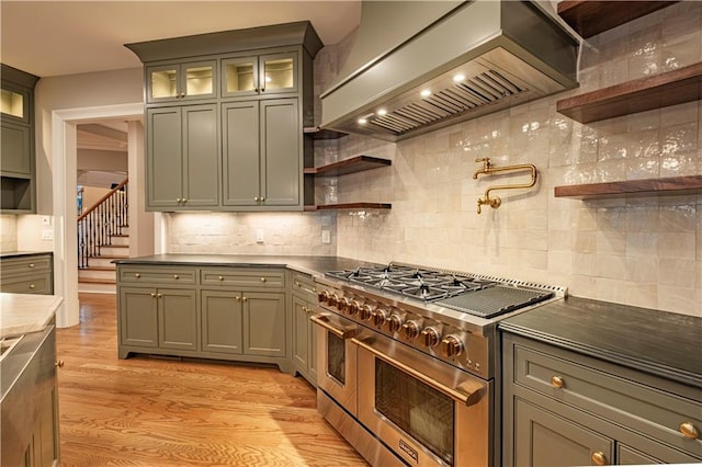 kitchen with open shelves, light wood-style floors, premium range hood, backsplash, and double oven range
