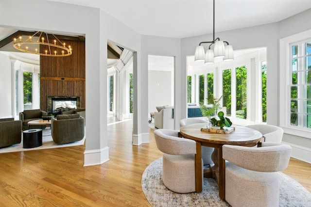 6756 Hedge Row Ln, Gainesville, GA 30506 - dining room with a chandelier, light wood-style flooring, baseboards, and a large fireplace