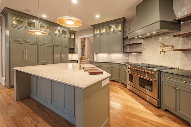 kitchen with open shelves, a sink, light wood-style flooring, range with two ovens, and custom range hood
