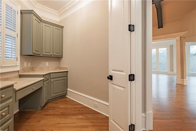 interior space with baseboards, ornamental molding, and wood finished floors