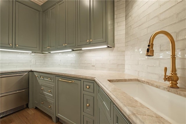 kitchen with light countertops, dark wood finished floors, a sink, and tasteful backsplash