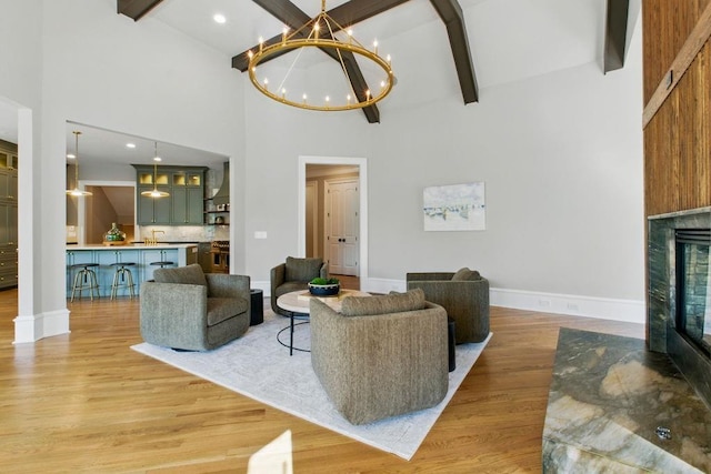 6756 Hedge Row Ln, Gainesville, GA 30506 - living area featuring a chandelier, beam ceiling, high vaulted ceiling, a glass covered fireplace, and light wood-type flooring